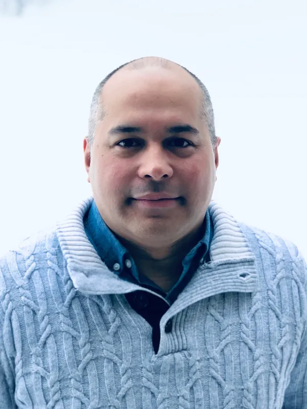 A man wearing a light blue sweater